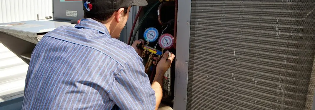 HVAC technician servicing a condenser unit in El Sobrante